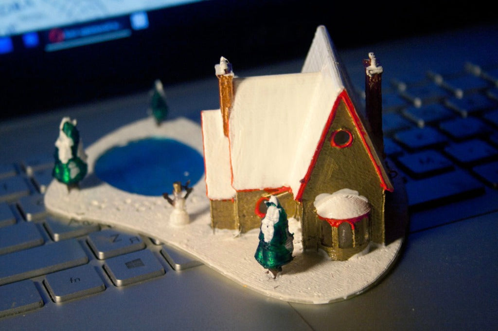 Wydrukowany w 3D domek bożonarodzeniowy z zamarzniętym jeziorem